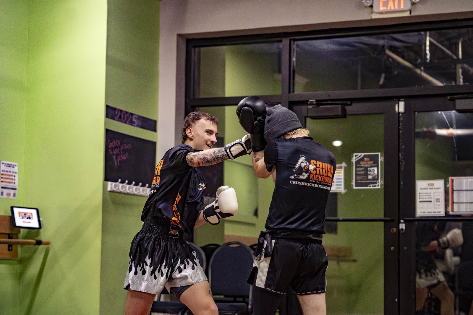 Adult throwing a knee strike in Muay Thai training at Crush Kickboxing