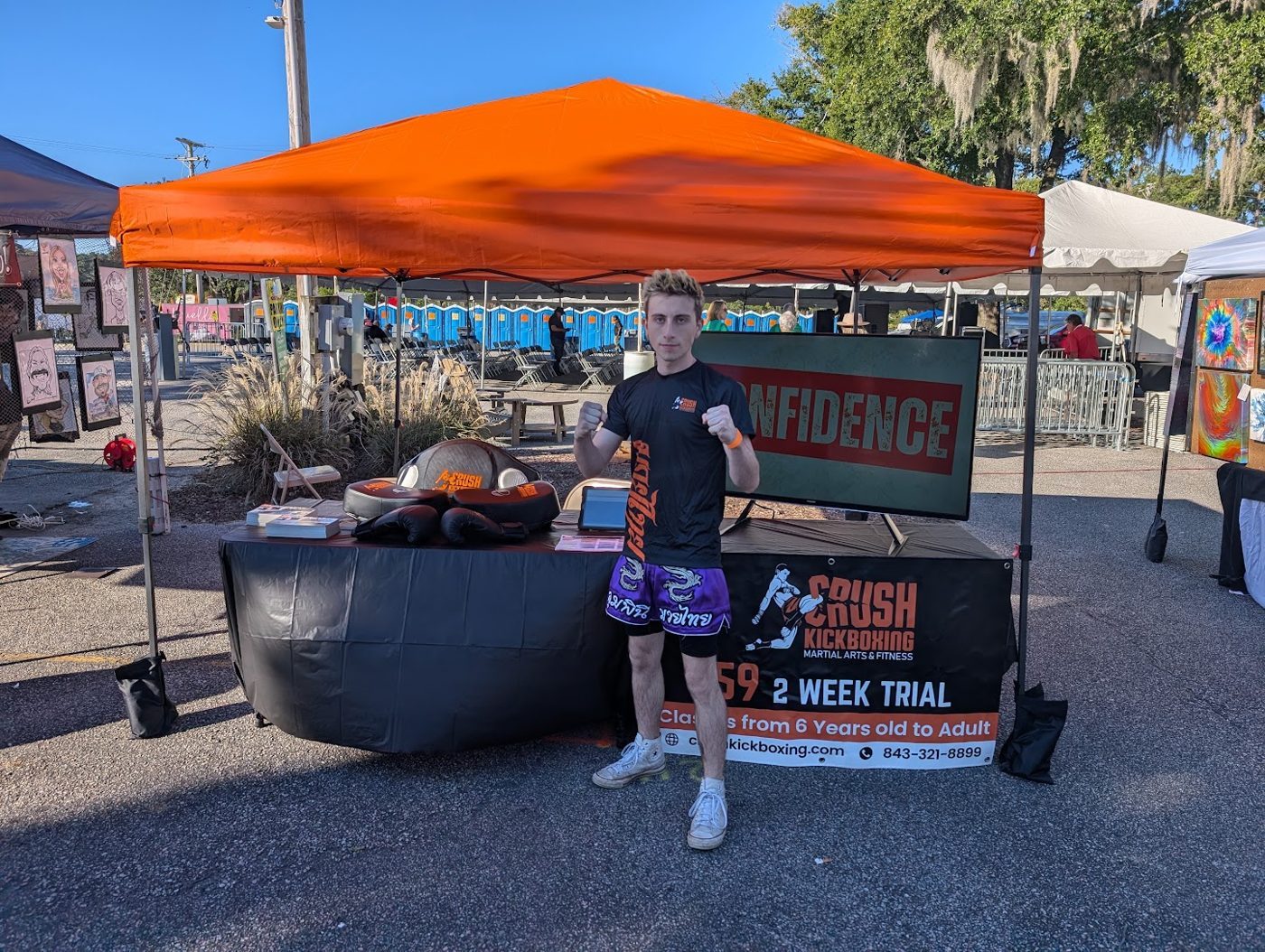 Coach Garrett (Coach G), Muay Thai instructor at Crush Kickboxing, at a community event booth